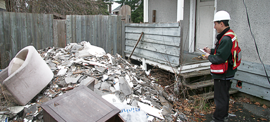 Certified environmental technician conducting hazardous materials inspection in building.